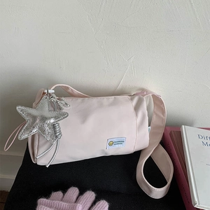 Detail of light pink crossbody bag with silver star charm and balloon dog pendant