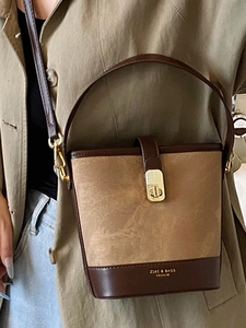 Vintage two-tone bucket bag with polished gold clasp and textured brown leather finish