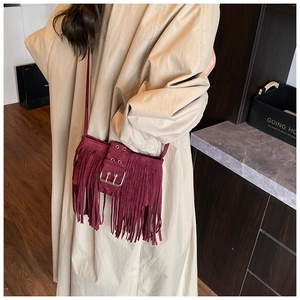 Vue détaillée du sac à franges en daim bordeaux avec boucle en métal dans un style bohème