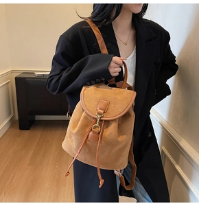 Close-up of a brown matte leather backpack with gold hook buckle and drawstring detail