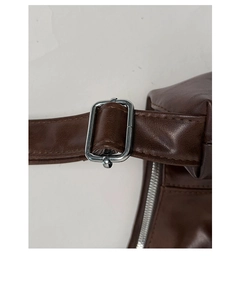 Detail of adjustable dark brown leather shoulder strap with silver metal buckle on a tote bag