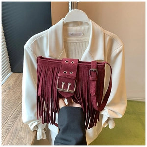 Vue détaillée du sac à bandoulière bordeaux à franges avec texture daim et boucle argentée