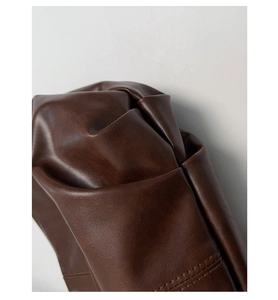 Detail of dark brown leather texture with neat double stitching on a designer handbag