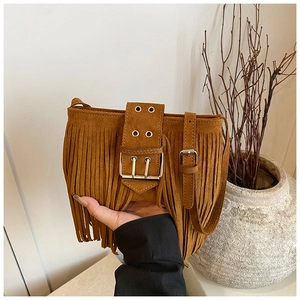 Gros plan d'un sac en daim marron avec franges bohèmes et boucle au style vintage rétro