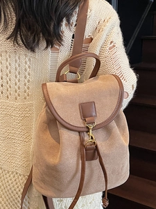 Vintage beige suede backpack with brown leather trim shown on model by stairs
