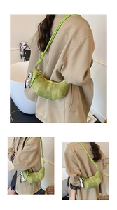 Detail of avocado green suede croissant bag with knot strap and polka dot accessory