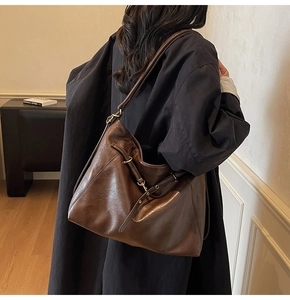 Détail macro du sac hobo vintage marron foncé avec boucle métallique dorée chic