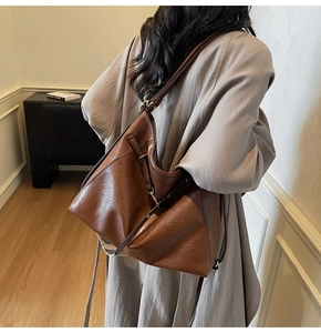 Détail de la vue arrière d'un grand sac cabas en cuir marron rétro porté par un mannequin