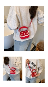 Détail du mini sac rouge à fleurs brodées et bordure en dentelle sur le rabat supérieur