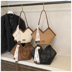 Detailed view of woven V-shaped tote bags with silk scarf accents and logo plate