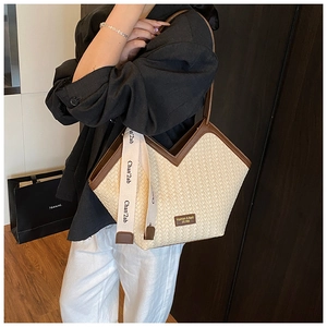 Detail of woven tote bag with V-shaped opening and brown leather contrast trim