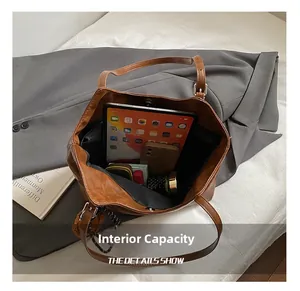 Macro view of brown leather tote bag interior showing large capacity for iPad and phone