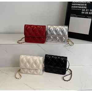 Bolsos de hombro acolchados en rojo, plata, crema y negro mostrados sobre mármol