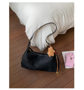 Detail of black matte suede baguette bag with cute teddy bear and colorful bead charm