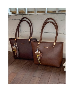 Detailed view of brown PU leather tote bags with minimalist straps and cute bear charms
