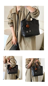 Detail view of black matte tote bag with cute brown plush bear charm and long straps