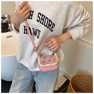 Vue détaillée du mini sac rose avec bordures en dentelle et fleurs 3D sur le rabat