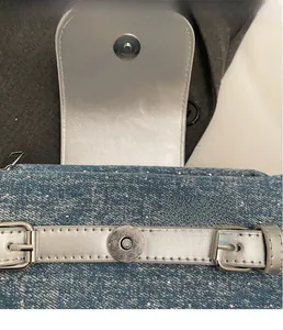 Detail of blue denim shoulder bag with sparkling rhinestones and silver hardware buckle