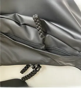 Detail view of smooth metal zipper and black woven rope puller on a waterproof crossbody bag
