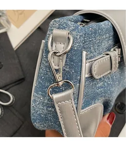 Detail of silver metal hook and strap on blue sequin denim shoulder bag for women