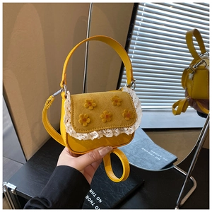 Détail du mini sac à main jaune avec décor fleuri et bordure en dentelle délicate