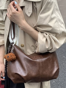 Brown vintage oil wax leather hobo bag with teddy charm shown on a model