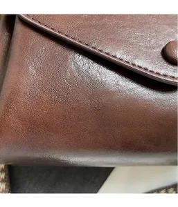 Detail of premium brown leather flap with magnetic closure and textured stitching