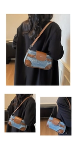 Detail view of denim shoulder bag with brown leather flap and stylish brand logo
