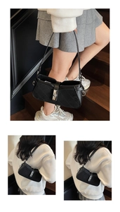 Detail of black quilted shoulder bag with silver metal clasp and polished leather texture