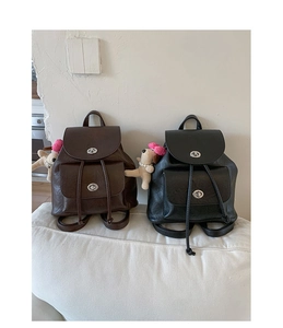 Detail of vintage mini backpacks in brown and black leather with plush puppy charm