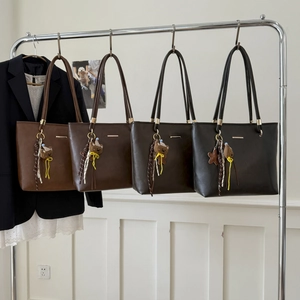 Detail of multi-color retro PU leather tote bags with cute cartoon bear charms and tassels