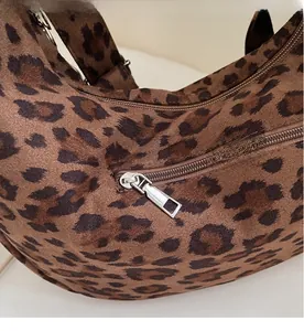Macro detail of the smooth metal zipper and leopard print fabric on this tote bag