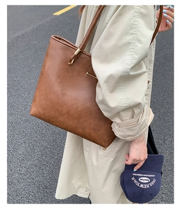 Detail of vintage brown tote bag with textured PU leather and elegant slim handles