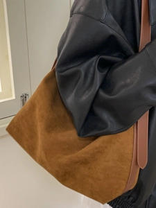 Brown matte suede tote bag with leather straps worn by a model for daily commuting