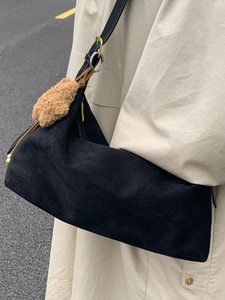 Retro black suede baguette bag with long shoulder straps and plush pendant charm for women