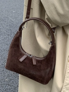 Brown suede crescent hobo bag with a hard round handle and a shoulder strap for women