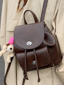 Vintage dark brown faux leather backpack with silver turn-lock and plush dog charm