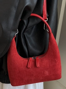 Minimalist red suede crescent underarm bag with circular handle and dual zipper