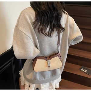 Detailed view of vintage beige canvas and brown leather crossbody saddle bag with metal lock