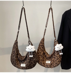 Detailed view of leopard print canvas hobo bags in dark and light brown with plush charms