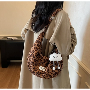 Detail of leopard print hobo bag with a plush cloud charm and wide shoulder strap