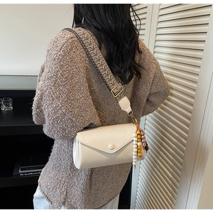 White leather crossbody bag with geometric woven strap and colorful bead charm detail