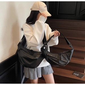 Comparison of two sizes of black nylon half-moon crossbody bags with wide straps