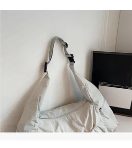 Detail of the nylon crossbody bag showing the adjustable strap and zipper closure