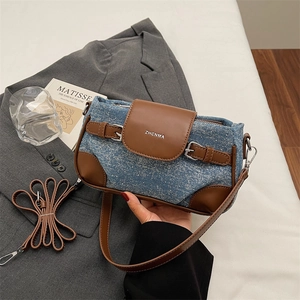 Detail of denim and brown leather crossbody bag featuring ZHCNMA silver logo hardware