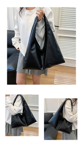 Lifestyle view showing the large capacity black leather tote bag worn as a shoulder bag