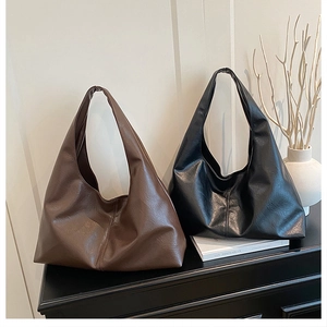 Detail of minimalist leather hobo bags in black and brown with natural soft texture