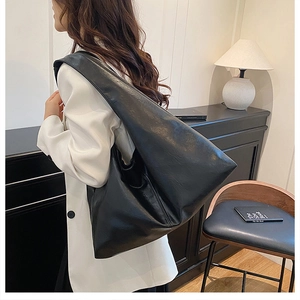 Close-up of the soft black leather tote bag with a spacious hobo design and glossy finish
