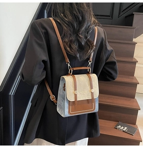 Vintage contrast-color backpack purse worn on back by model on stylish indoor stairs