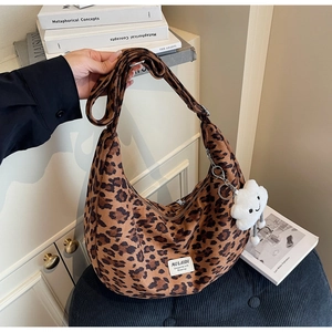 Close-up of leopard print hobo bag with adjustable strap and white cloud charm